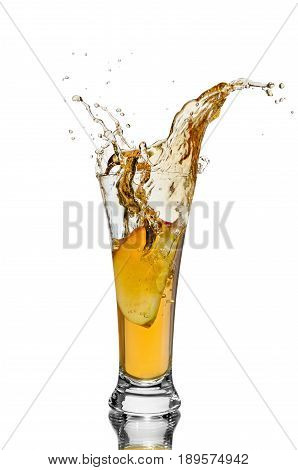a piece of Apple falling into a glass of juice on white isolated background