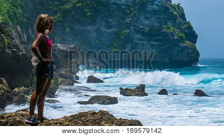 Girl standing on Tembeling Beach with view of coastline at Nusa Penida island, Bali Indonesia.