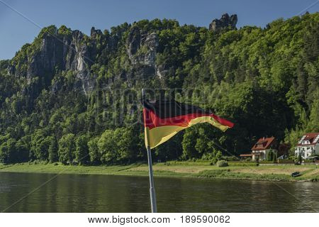 Germany flag on ferry boat in Kurort Rathen town in spring sunny day