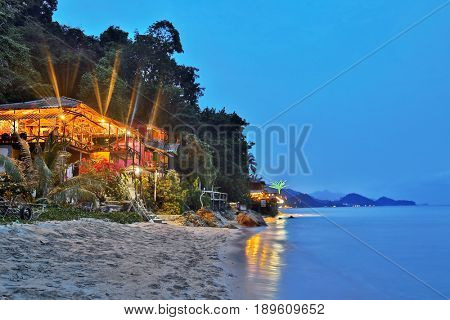 Cheap bungalows for backpackers on a tropical beach in evening time. Thailand