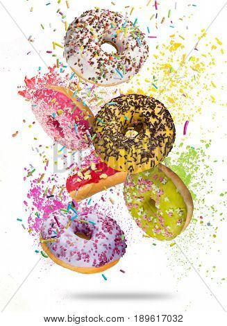 Tasty doughnuts in motion falling on white background, close-up.