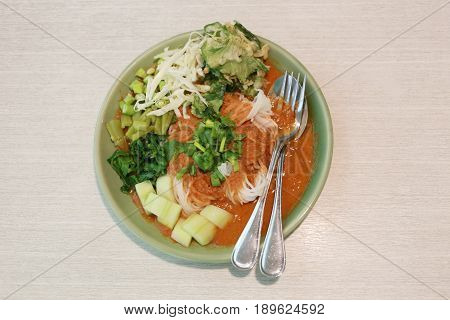 Thai Noodles (Kanom jeen) in a green dish on a food table.