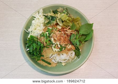 Thai Noodles (Kanom jeen) in a green dish on a food table.