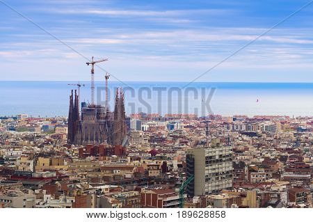 Barcelona Spain - 1 April 2017: Beautiful view on Sargada Familia being constructed and a cityscape of Barcelona in cloudy weather view from the Park Guell.