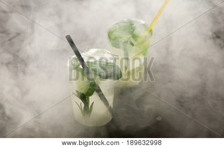 two glasses with fresh cocktail made of ice on concrete table. concept
