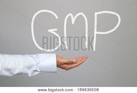 Hand of businessman and hand drawn text GMP system for idea presentation in your organization and work.