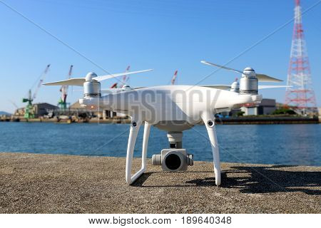KAGAWA, JAPAN - MAY 28, 2017: White drone Dji Phantom4Pro stay on concrete blocks for protection of port and ready to fly.