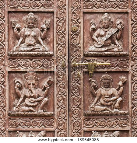 Detail wooden carved door in hindu temple Kathmandu Nepal background. Close up vintage antique door with ornament