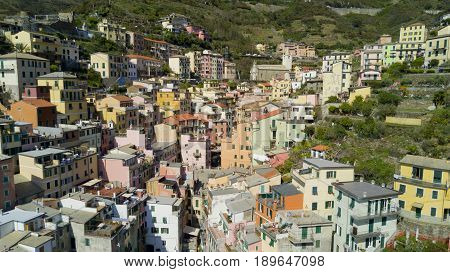 Aerial shooting with drone on Riomaggiore, one of the famous Cinqueterre country, small village with colored houses on the cliff over the sea