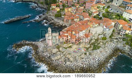 Aerial video shooting with drone on Tellaro, famous Ligurian village near the Cinqueterre, small colored houses built on the cliff by the sea