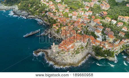 Aerial video shooting with drone on Tellaro, famous Ligurian village near the Cinqueterre, small colored houses built on the cliff by the sea