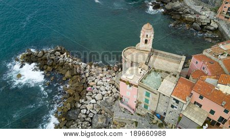 Aerial video shooting with drone on Tellaro, famous Ligurian village near the Cinqueterre, small colored houses built on the cliff by the sea