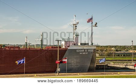 Sault Ste Marie, Michigan, USA - May 31, 2014: A massive Great Lakes freighter at Soo Locks. The Locks are the busiest in the world with over 500 billion dollars of iron ore transported through them.