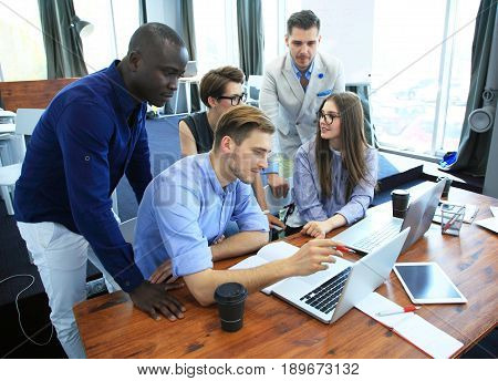 Teamwork concept.Young creative coworkers working with new startup project in modern office.Group of people analyze data on desktop computer.