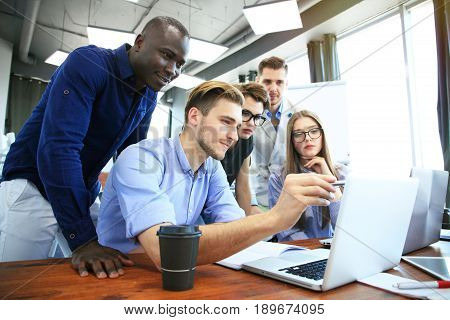 Teamwork concept.Young creative coworkers working with new startup project in modern office.Group of people analyze data on desktop computer.