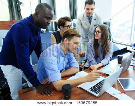 Teamwork concept.Young creative coworkers working with new startup project in modern office.Group of people analyze data on desktop computer.