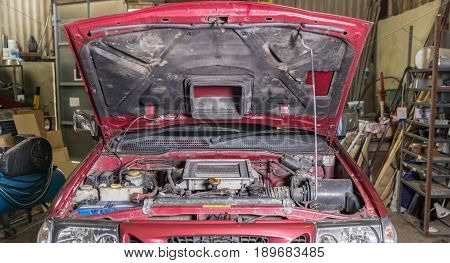 Car In A Workshop With Its Bonnet Up And Engine Showing