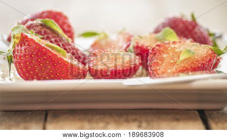strawberries cut with sugar and mint close up