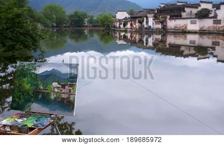 HONGCUN, CHINA - APRIL 20, 2014: Easel with a picture in the background of a landscape in Hongcun Village, Anhui Province of China