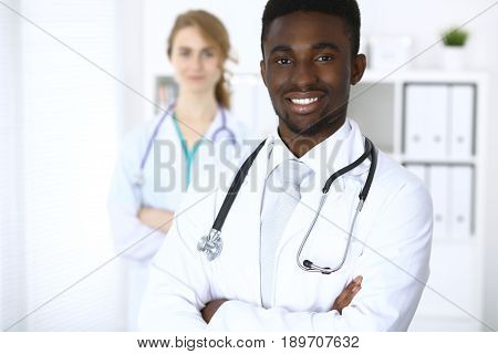 Happy african american male doctor with medical staff at the hospital.