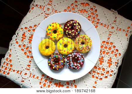 Yellow and brown donuts on a white plate