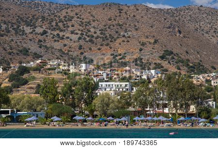 Elounda Crete Greece 22 September 2013: Beach with holidaymakers people near the village of Elounda. The Bay of Mirabello