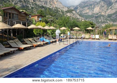 30TH MAY 2017, KABAK, TURKEY : English tourists having a swim and cooling off in an infinity pool at the olive garden in Kabak in Turkey, 30th may 2017