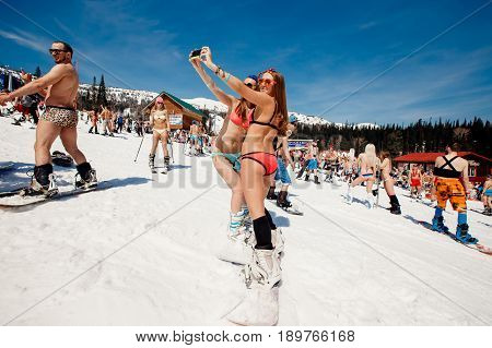 Sheregesh, Kemerovo region, Russia - April 16, 2016: Grelka Fest is a sports and entertainment activity for ski and snowboard riders in bikini.group of snowboarders friends in swimsuits.