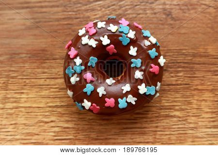 Single brown donut on a wood background