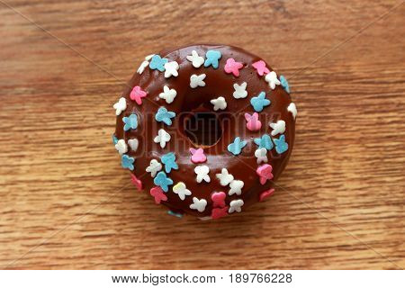 Single brown donut on a wood background