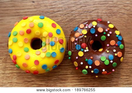 Two assorted donuts on a wood background