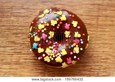 Single brown donut on a wood background