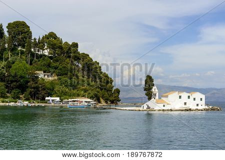 KANONI, GREECE - MAY 15: Tourists visit the old Greek Christian Orthodox church Vlacherna Monastery on May 15, 2017 in Kanoni, Corfu island in Greece.