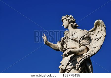 Angel statue holding the Nails of Jesus Cross on Sant'Angelo Bridge in Rome (with blue sky and copy space)