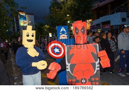 Quito, Ecuador - December 31, 2016: An unidentified group of people dreessed as deadpool, captain America, and lego man, celebrating new years gathering in city streets.