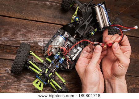 Rc radio control car crawler model toy electronics repair. Green toy suv in repairshop workplace, free space