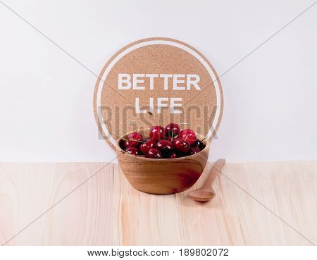 Cherries in a wooden bowl and wooden spoon and inspiration words