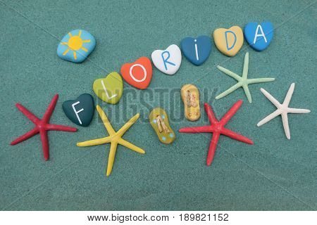 Florida, USA, souvenir with colored stone hearts and starfishes over green sand