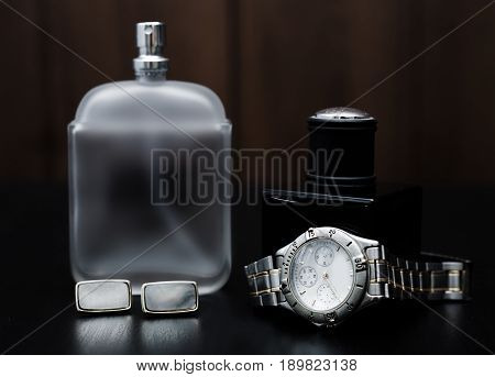 Male perfume and watches on a wooden background. Men's Accessories