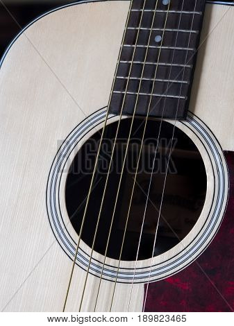 Close up shot of acoustic guitar. Strings sound hole bridge pickguard