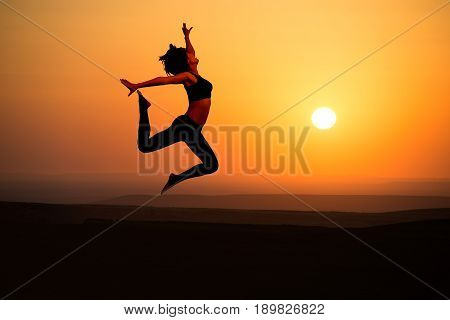 Young woman dancer on outdoor unrise background.