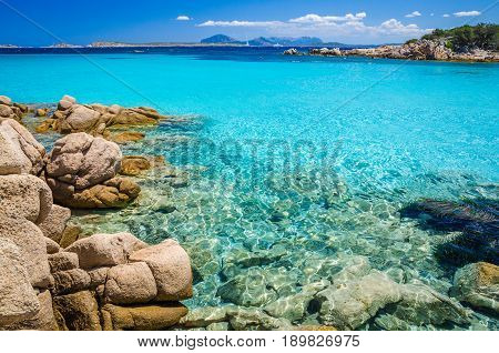 Clear amazing azure coloured sea water with gtanote rocks in Capriccioli beach, Sardinia, Italy.