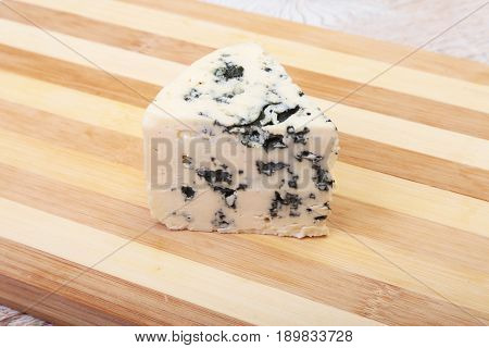 Plate with Tasty blue cheese on wooden table.
