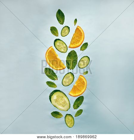 Summer Food and Drink - Fruit Lemonade Ingredient Pattern made of Cucumber, Orange and Mint. Splash Shape with Flying Drink Ingredient. Summer Fruit Drink Ingredient Concept. Flat Lay