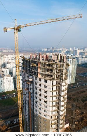 věžový jeřáb vyzdvihnutí betonových bloků zatížení na vrcholu budovy ve výstavbě