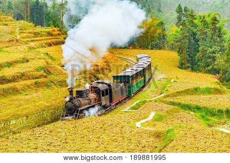 Steam narrow-gauge train moves from Yuejin to Bagou through the chinese countryside. Jiayang Mining Region. Sichuan province. China.