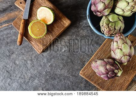 Baby Ripping Organic Artichokes With Lemon. Food For A Vegan And