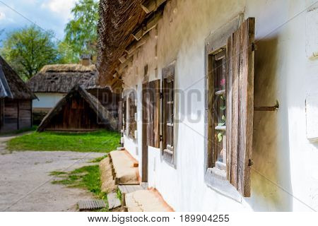 Ancient peasant Ukrainian house in the spring with a thatched roof in the old village of national architecture Ukraine. Ancient peasant Ukrainian house in the spring with a thatched roof in the old village of national architecture Ukraine. National Museum