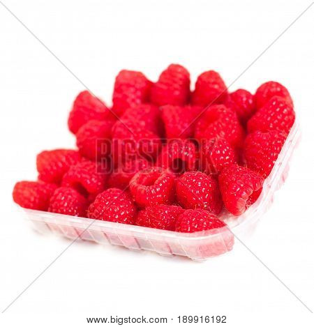 Ripe raspberries isolated on white background in a plastic box close up macro