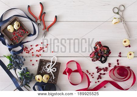 Making jewelry, home workshop background. Flat lay, tools and materials for creating accessory with beads and ribbons, top view, copy space. Beauty, creativity, handicraft concept
